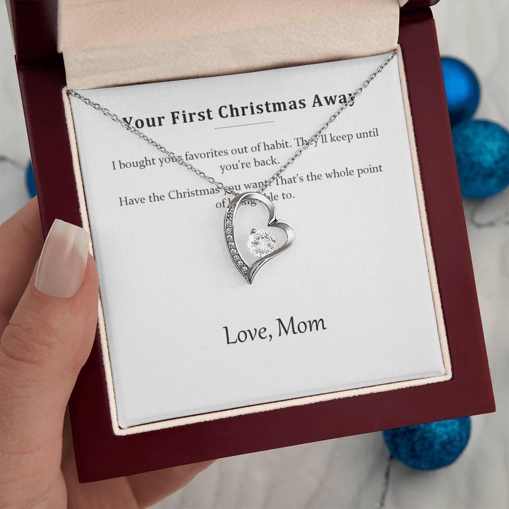 Hand holding the luxury gift box containing the silver heart necklace and message card