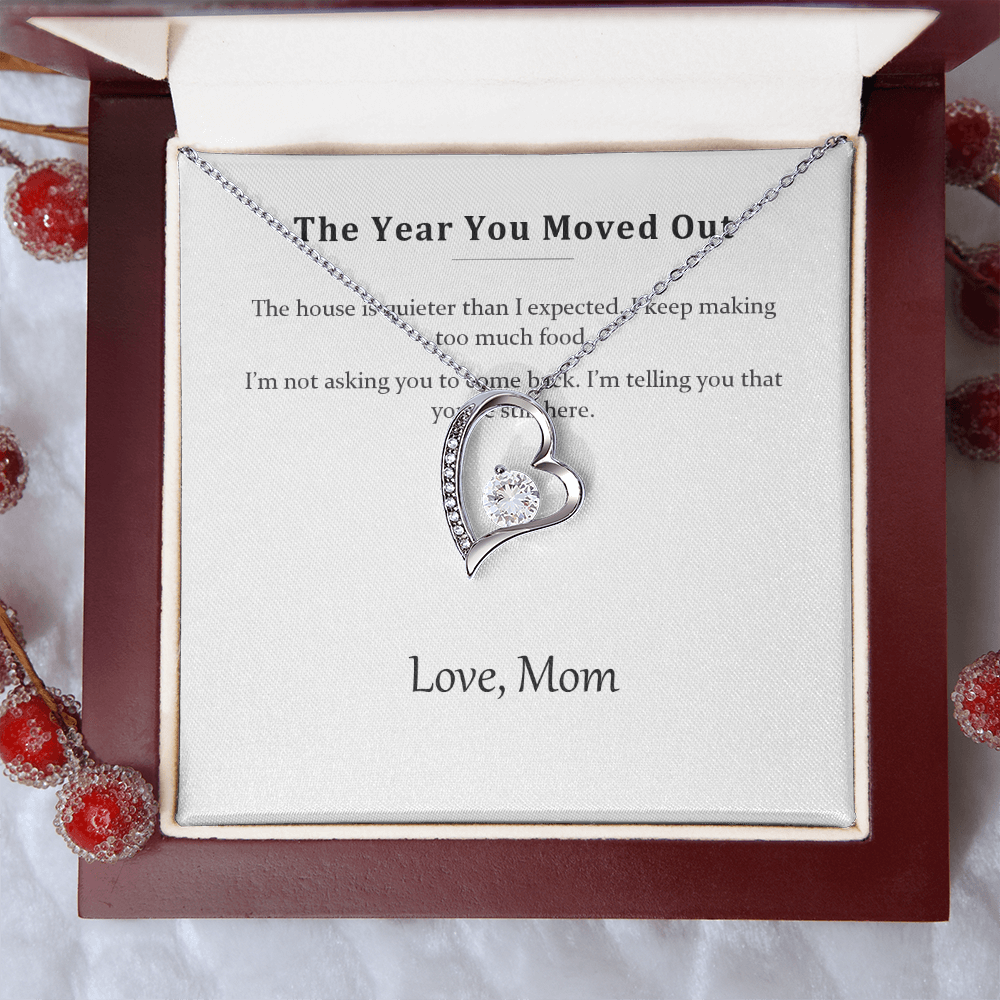 Silver heart necklace on the message card, styled with red winter berries