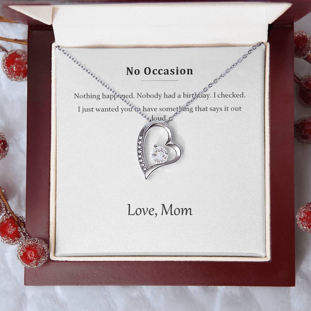 Silver heart necklace on the message card, styled with red winter berries