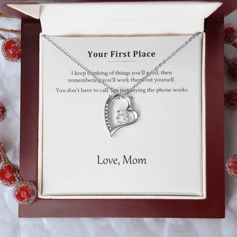 Silver heart necklace on the message card, styled with red winter berries