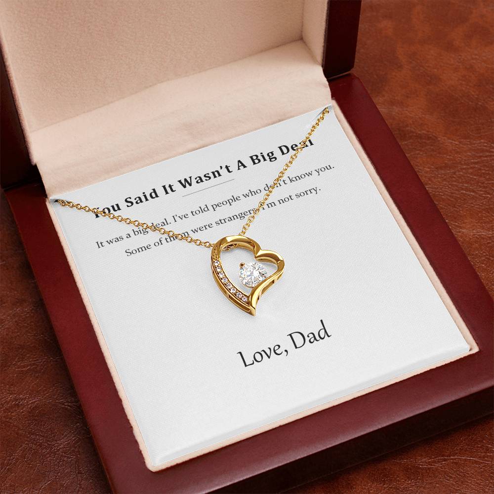 Gold heart necklace displayed on the message card inside the luxury gift box