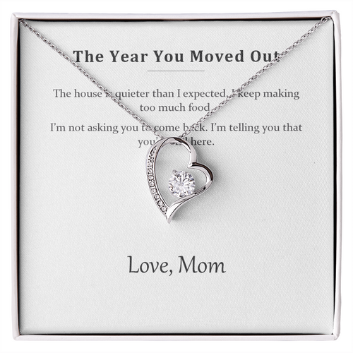 Silver heart pendant necklace on a printed message card reading The Year You Moved Out, in a white gift box