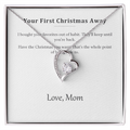 Silver heart pendant necklace on a printed message card reading Your First Christmas Away, in a white gift box