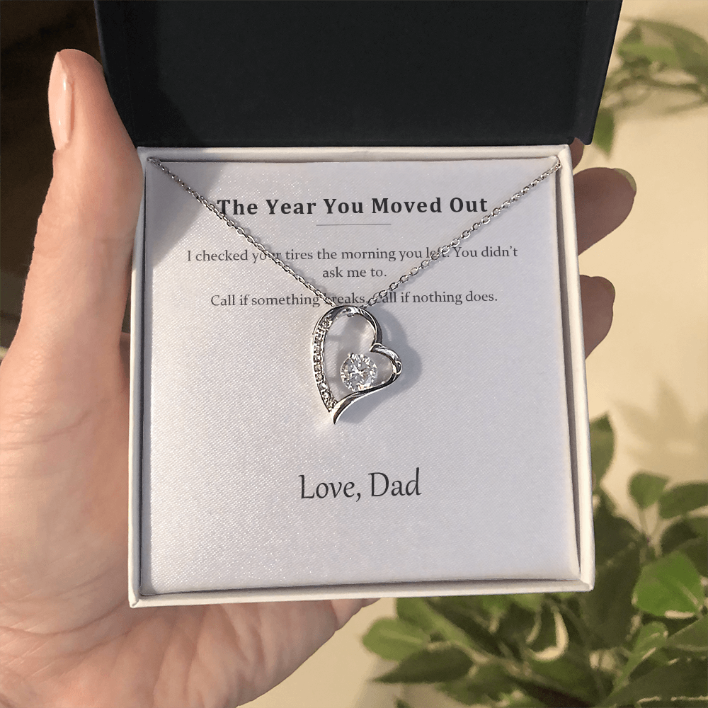 Hand holding the open gift box with the silver heart necklace and its printed message card