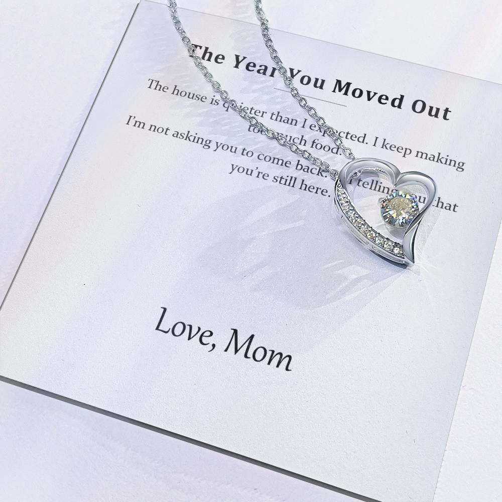 Close view of the printed message card with the silver heart pendant resting on it