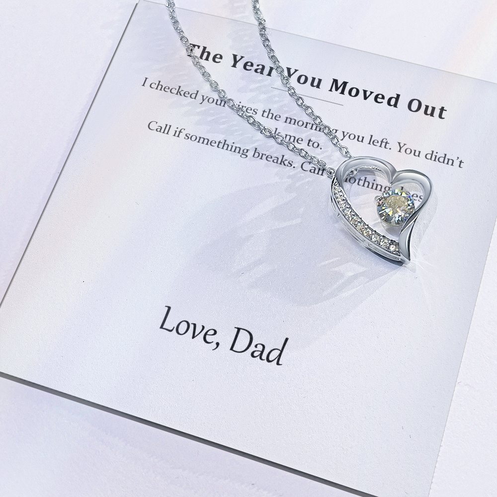 Close view of the printed message card with the silver heart pendant resting on it