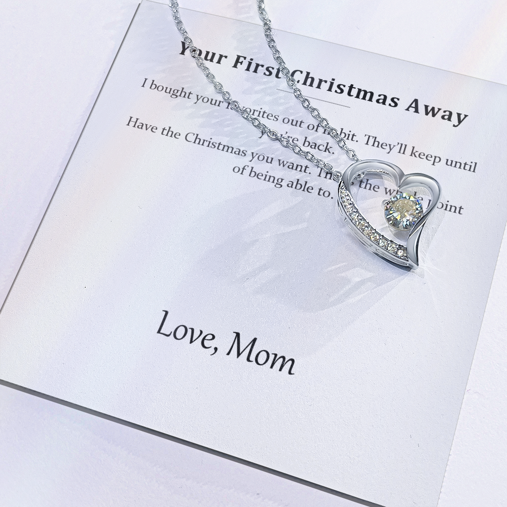 Close view of the printed message card with the silver heart pendant resting on it
