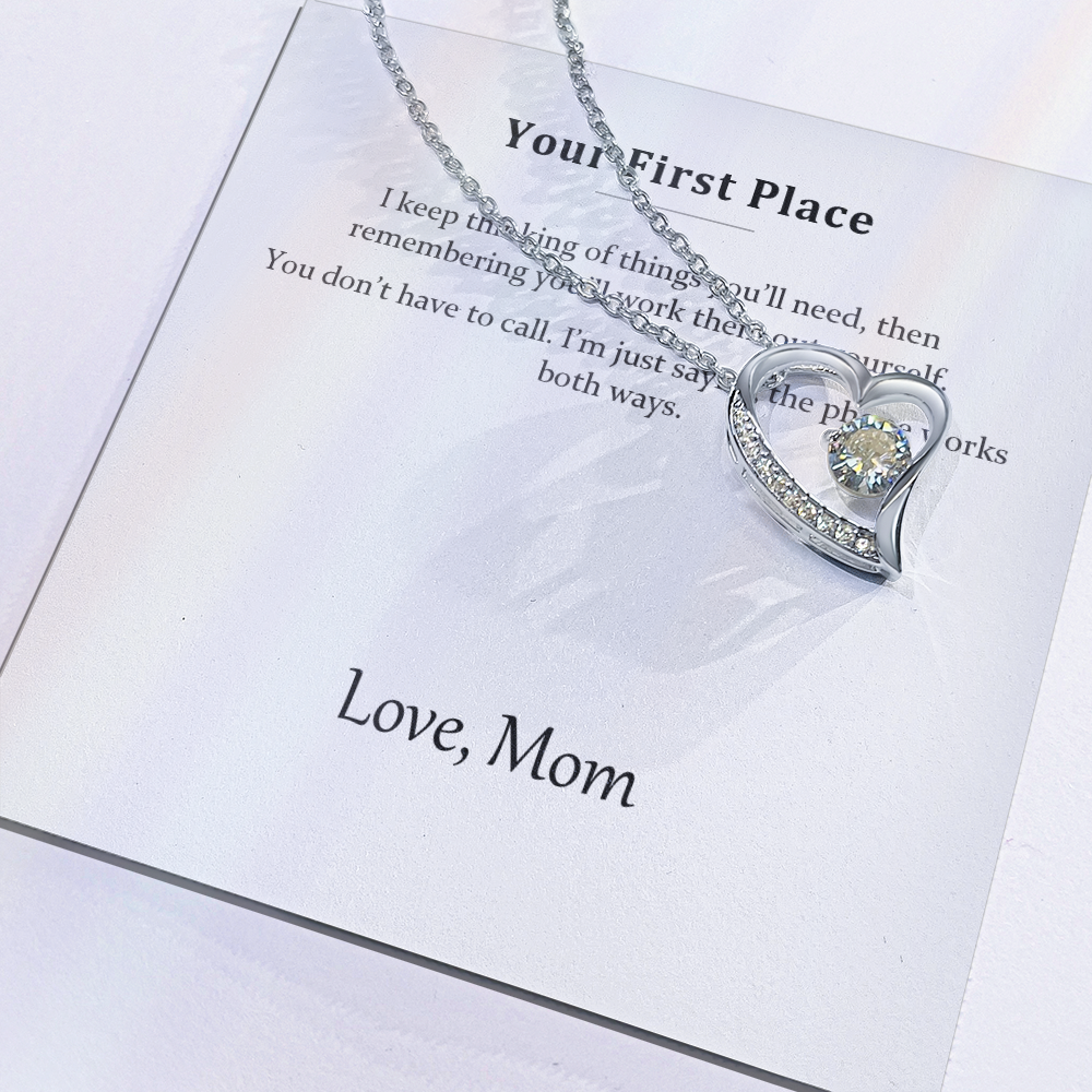 Close view of the printed message card with the silver heart pendant resting on it