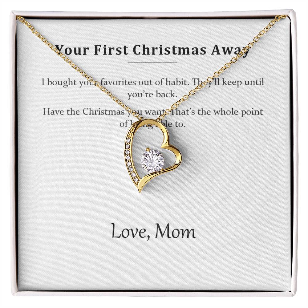 Gold heart pendant necklace on the Your First Christmas Away message card in a white gift box