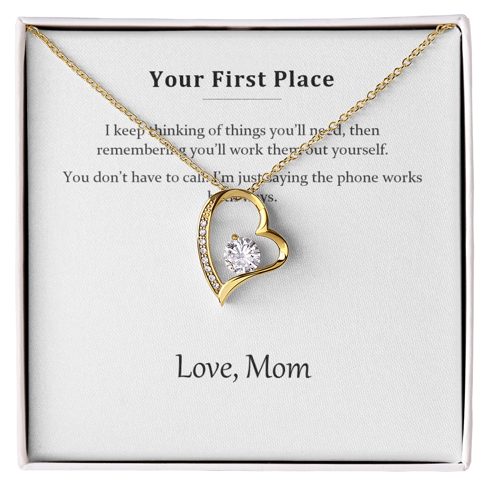Gold heart pendant necklace on the Your First Place message card in a white gift box