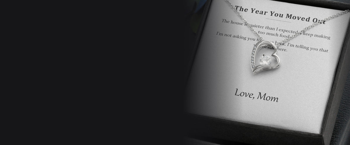 A message card necklace resting in its box, with the printed card visible beside it